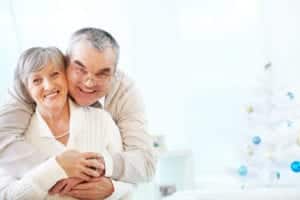 Portrait of a happy senior couple embracing and looking at camera