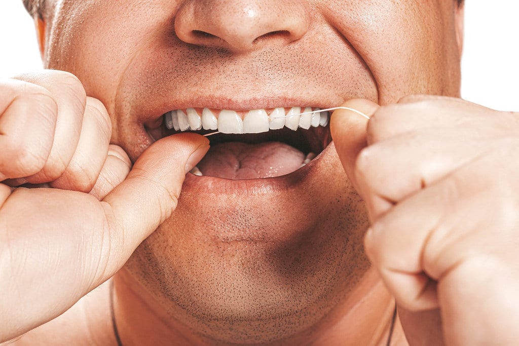 A man Flossing his teeth
