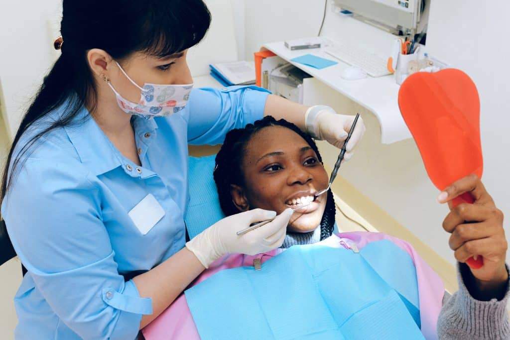 A Dentist cleaning a woman's teeth